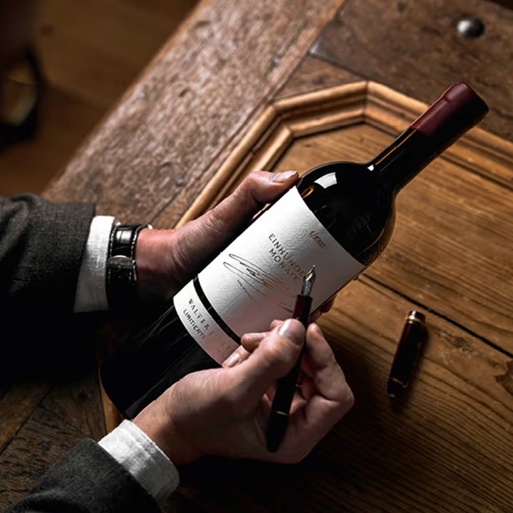 Garrafa de vinho sendo assinada